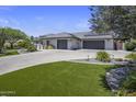 Attractive property featuring an extended driveway with a multi-car garage and well-maintained artificial turf at 5926 E Hartford Ave, Scottsdale, AZ 85254