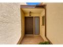 Covered front door with security light, window and textured stucco at 6 E Manzanita Dr, Phoenix, AZ 85020