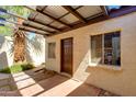 Enclosed patio area with a partial pergola, accent wall, and secure door at 6 E Manzanita Dr, Phoenix, AZ 85020