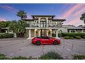 Beautiful two-story home with a black wrought iron balcony and a sporty red convertible in the driveway at 6611 N 64Th Pl, Paradise Valley, AZ 85253
