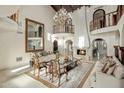 Open living room with grand fireplace, soaring ceilings, chandelier, and balcony overlooking at 6611 N 64Th Pl, Paradise Valley, AZ 85253