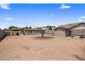An expansive backyard with gravel, featuring additional structures for storage and utility at 901 E Hearn Rd, Phoenix, AZ 85022