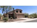 Charming two-story home featuring a two-car garage and desert landscaping at 10399 E Hillery Dr, Scottsdale, AZ 85255