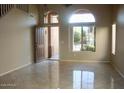 Spacious living room featuring tile flooring, arched windows, and an open entryway at 10399 E Hillery Dr, Scottsdale, AZ 85255