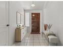 Bright foyer featuring tile flooring, white walls, and a wooden front door with adjacent furniture accents at 1135 W Sea Fog Dr, Gilbert, AZ 85233
