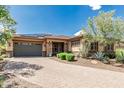 Charming single-story home with stone accents, a paved driveway, desert landscaping, and a two-car garage at 13720 N 148Th Dr, Surprise, AZ 85379