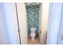 Stylish powder room featuring vibrant tropical leaf wallpaper, adding character to the space at 16021 N 30Th St # 127, Phoenix, AZ 85032