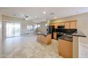 The kitchen features wooden cabinets, dark appliances, an island, and plenty of counter space at 16528 W Lariat Ln, Surprise, AZ 85387
