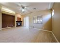 Open living room with a fireplace, ceiling fan, sliding doors and natural light at 16528 W Lariat Ln, Surprise, AZ 85387