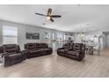 Open concept living room featuring tile floors, leather furniture, and abundant natural light from the windows at 18362 W Illini St, Goodyear, AZ 85338