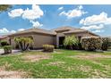 Beautiful residence showcasing well-kept landscaping, mature palm trees, and a tidy green lawn at 20826 S Hadrian Way, Queen Creek, AZ 85142