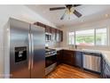 Modern kitchen featuring stainless steel appliances, dark wood cabinets, tile backsplash, and wood-look floors at 2214 N 7Th Ave, Phoenix, AZ 85007