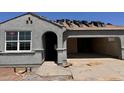 Gray stucco home with a tile roof being installed and an arched front entry at 22720 N Lynn St, Maricopa, AZ 85138