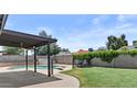 Inviting backyard featuring a refreshing pool, covered patio, and lush green lawn perfect for outdoor relaxation at 2435 E Harmony Ave, Mesa, AZ 85204