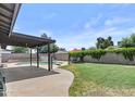 Private backyard featuring a pool, covered patio, grassy area and block fence at 2435 E Harmony Ave, Mesa, AZ 85204