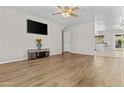 Open living room with wood-look flooring, a ceiling fan, and great natural light at 2435 E Harmony Ave, Mesa, AZ 85204