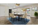 Open dining area with modern chairs, a ceiling fan, and sliding door access to the backyard pool at 2608 W Columbine Dr, Phoenix, AZ 85029