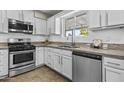 Modern kitchen features stainless steel appliances, granite countertops, and white cabinetry at 2608 W Columbine Dr, Phoenix, AZ 85029