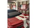 Garage interior with a red sports car, American flag, and organizational ladder at 2840 W Marlette Ave, Phoenix, AZ 85017