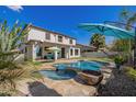 Beautiful pool and spa with a baja step surrounded by travertine and lush landscaping at 3190 S Holguin Way, Chandler, AZ 85248