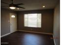 Inviting living room with dark hardwood floors, a bright window, and a ceiling fan at 327 E La Jolla Dr, Tempe, AZ 85282