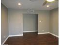Open living room with dark hardwood floors, neutral paint, and an open doorway to another room at 327 E La Jolla Dr, Tempe, AZ 85282