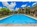 Community pool with water features, lounge chairs, landscaping, and well-maintained grounds at 3900 E Baseline Rd # 137, Phoenix, AZ 85042