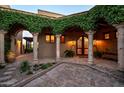 Stunning arched courtyard features mature climbing plants, a brick-paved area, and custom ironwork on the front entry doors at 40039 N 107Th Pl, Scottsdale, AZ 85262