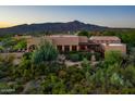 Desert home featuring a tiled roof, pergola, lush landscaping, covered porch, and mountain views at 40039 N 107Th Pl, Scottsdale, AZ 85262