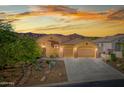 Home exterior showcasing desert landscaping, three-car garage, and warm exterior paint at 4281 S Tecoma Trl, Gold Canyon, AZ 85118