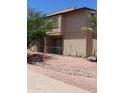 Two-story condo with a patio, desert landscaping, and gravel ground cover at 7120 E Wilshire Dr # 10, Scottsdale, AZ 85257