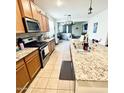 Well-lit kitchen featuring granite countertops, stainless steel appliances, and an open view to the living area at 9825 W Trumbull Rd, Tolleson, AZ 85353