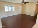 This brightly lit living room has hard wood floors, fresh paint, and a ceiling fan at 1018 W Helena Dr, Phoenix, AZ 85023