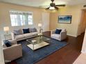 This well-staged living room showcases neutral walls, hardwood floors, and a ceiling fan at 1018 W Helena Dr, Phoenix, AZ 85023