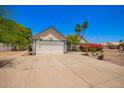 Charming home featuring a two-car garage, lush landscaping, and a stone walkway at 12529 N 83Rd Ln, Peoria, AZ 85381