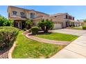Beautiful home featuring a well-manicured lawn, mature trees, and a welcoming entrance at 13005 W Vista Paseo Dr, Litchfield Park, AZ 85340