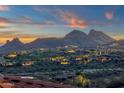 Scenic community view with illuminated homes nestled amidst desert landscape with mountain backdrop at sunset at 15536 E Heavenly Vista Trl, Fountain Hills, AZ 85268