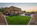 Expansive backyard with a covered patio, lush green lawn, and ample space for outdoor activities at 157 N 110Th Ave, Avondale, AZ 85323