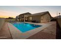 Private backyard oasis with a sparkling pool, tanning deck, and a comfortable seating area at 157 N 110Th Ave, Avondale, AZ 85323
