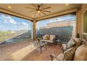 Cozy covered patio featuring comfortable seating, a ceiling fan, and views of the lush landscaping at 1617 E Copper Holw, Queen Creek, AZ 85140