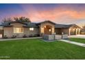View of the home with a green lawn and an inviting front entrance with modern architectural details at 1801 E Berridge Ln, Phoenix, AZ 85016