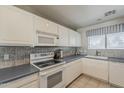 Bright kitchen featuring white appliances, tile backsplash, and ample counter space at 205 N 74Th St # 227, Mesa, AZ 85207
