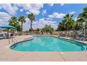 Community pool featuring crystal-clear water and lush landscaping with palm trees at 2286 E Mohave Ln, Apache Junction, AZ 85119