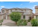Charming two-story home with a two-car garage and desert landscaping, complemented by mature shade trees at 23010 E Pummelos Rd, Queen Creek, AZ 85142