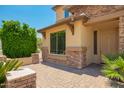 Close up view of a home featuring stone accents and a paver walkway to the front door at 26080 N 73Rd Ln, Peoria, AZ 85383