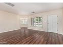 Bright living room featuring wood flooring, plantation shutters, and a view into another room at 2807 N 8Th Ave, Phoenix, AZ 85007