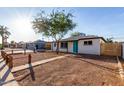 Charming single-story home featuring desert landscaping and a vibrant turquoise front door at 3012 W Butler Dr, Phoenix, AZ 85051