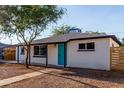 Charming single-story home featuring desert landscaping and a vibrant turquoise front door at 3012 W Butler Dr, Phoenix, AZ 85051