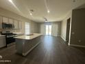 A modern kitchen area features sleek gray cabinetry and a large island at 40816 W Sunland Dr, Maricopa, AZ 85138