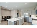 Open concept kitchen with a large island, stainless steel appliances, and adjacent dining area at 40816 W Sunland Dr, Maricopa, AZ 85138